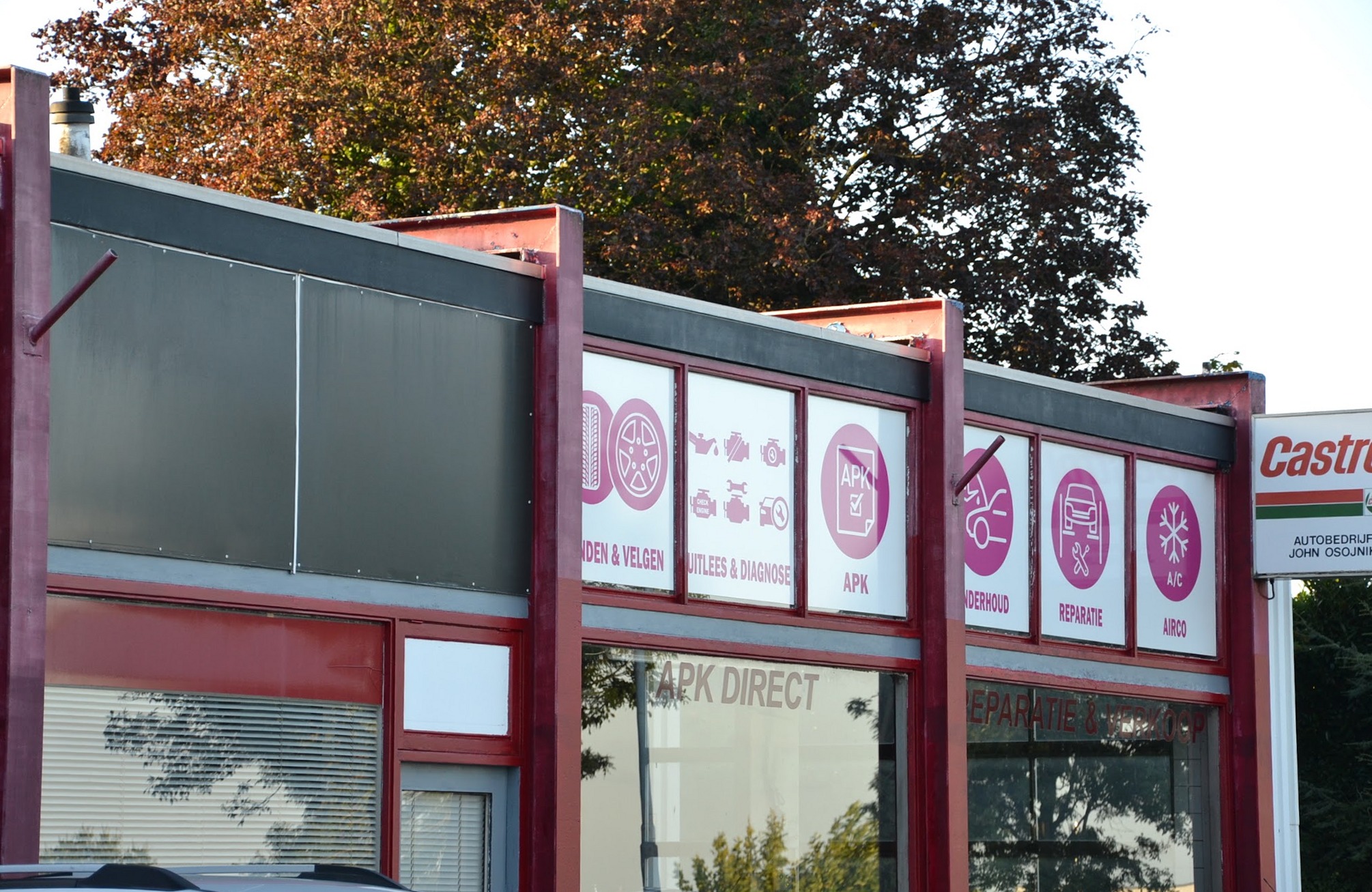 De gevel van Autobedrijf Arsen met rode kozijnen en de panelen voor APK, onderhoud, reparatie en airco